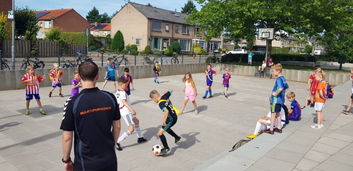 Buurtsportcoach Patrick van de Ven met sportende kinderen tijdens de vakantie