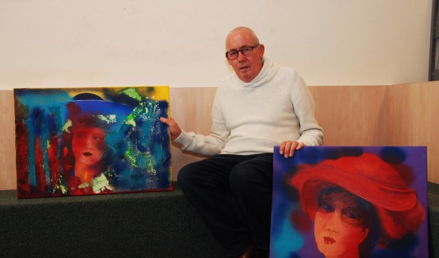 Hans van Leeuwen met twee van zijn schilderijen.