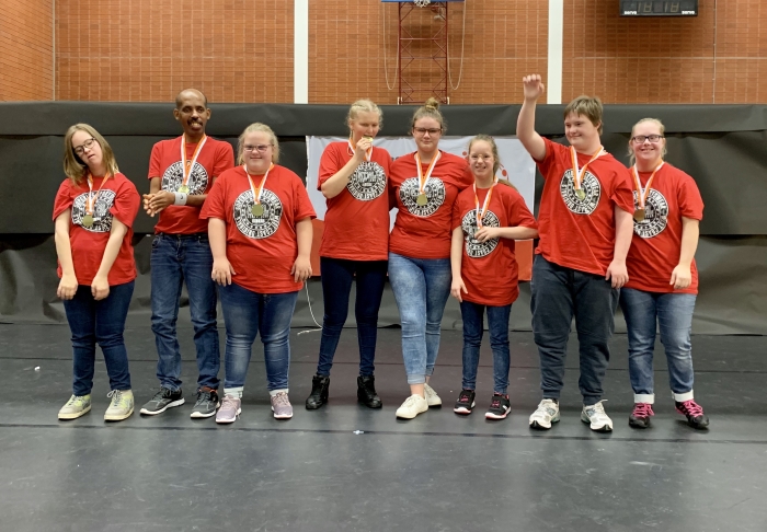 De trotse groep dansers met hun gewonnen medaille
