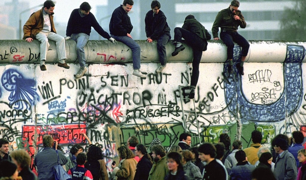 Enthousiaste inwoners uit Oost-Berlijn genieten op 10 november van het uitzicht aan de andere kant van de Berlijnse Muur. De Antifaschistischer Schutzwall, zoals de DDR het bouwwerk noemde, zorgde 28 jaar voor een tweedeling in de stad. 