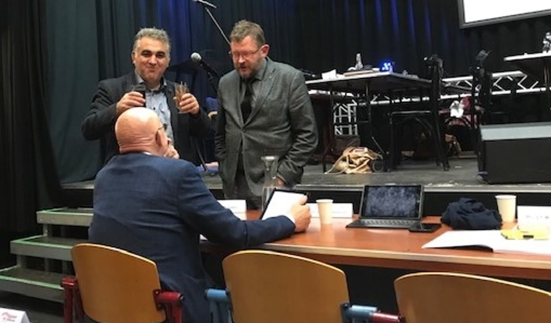 Wethouder Dick van Zanten tijdens de schorsing in gesprek met de raadsleden Hans van Mourik en Ali Kocak
