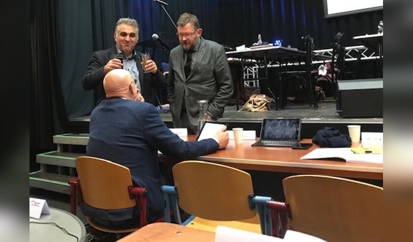 Wethouder Dick van Zanten tijdens de schorsing in gesprek met de raadsleden Hans van Mourik en Ali Kocak