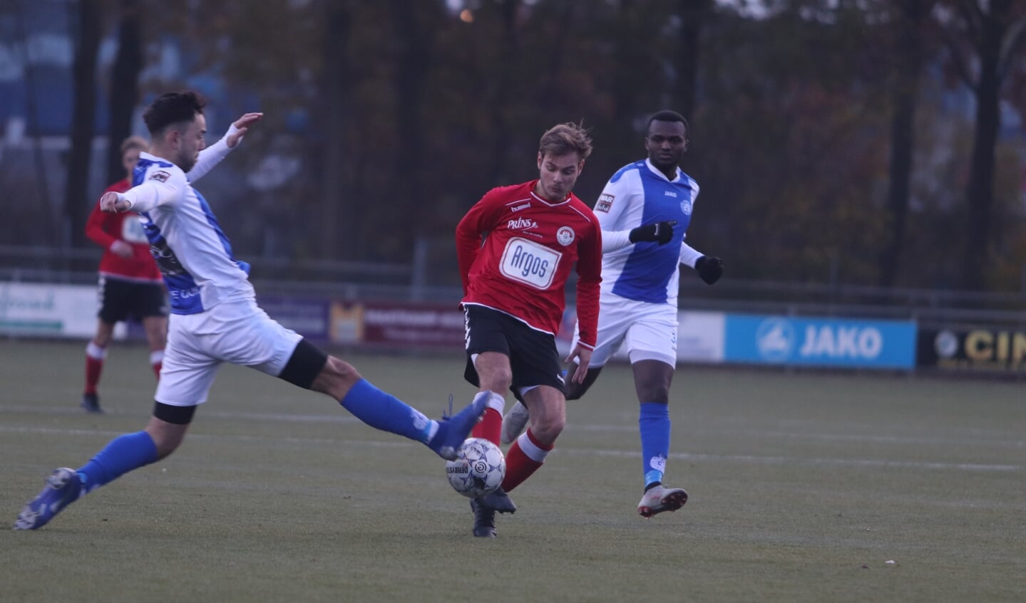 Thijs Klopper probeert namens Renswoude de bal langs een Zutphenaar te spelen.