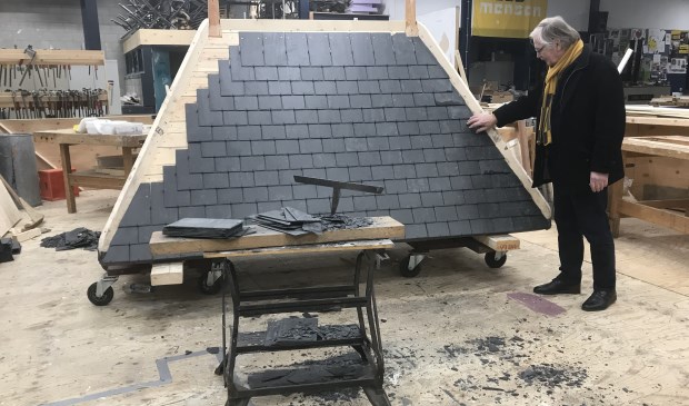 Bernard Siera bij de kapconstructie die al deels met leistenen is bekleed