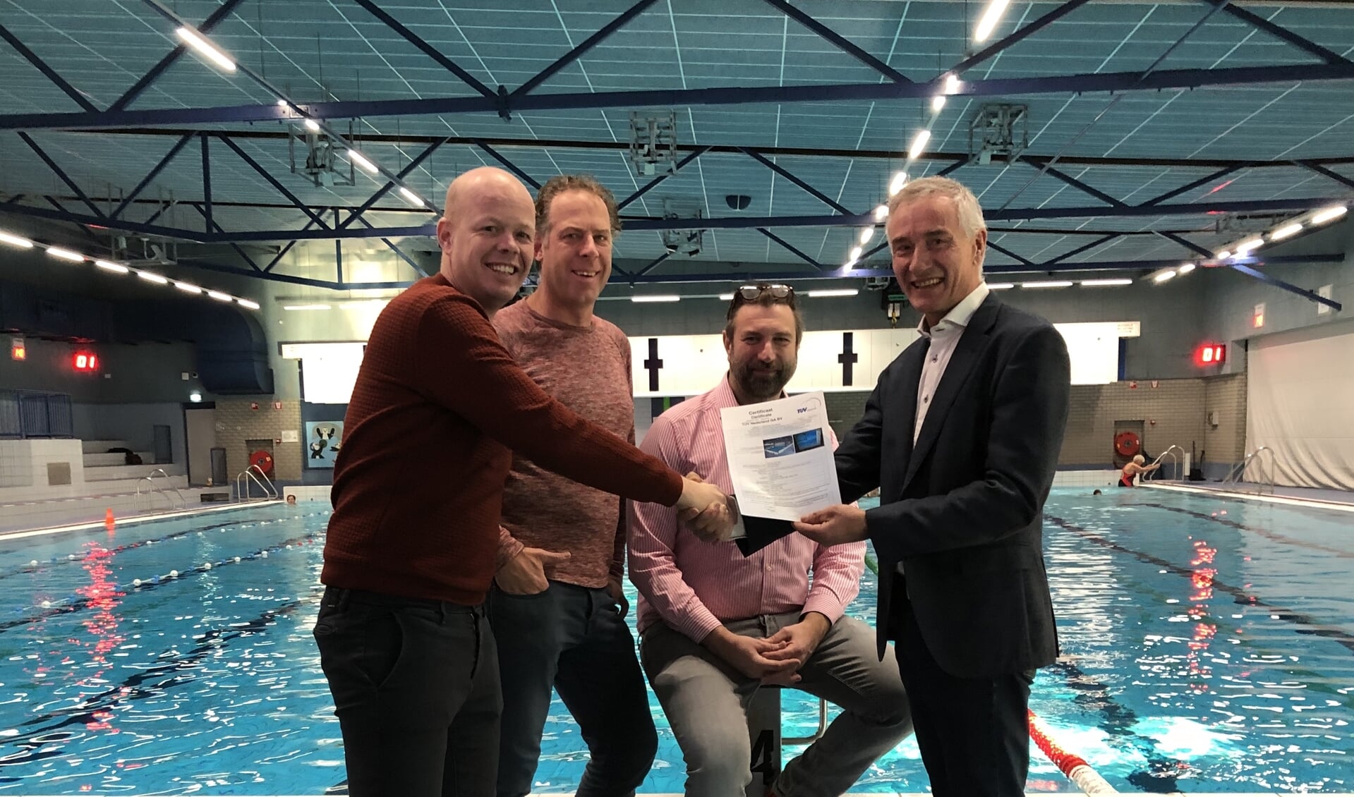 Tim van de Kolk, Boris Meijer en directeur Ronald ter Hoeven van Zwembad de Peppel ontvangen van directeur Peter Goedhart van Eyeview Systems het wereldwijd eerste  ISO-certificaat voor het drenkelingendetectiesysteem.