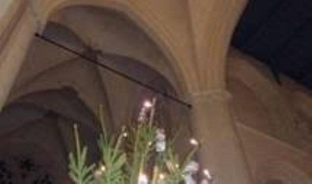 Boven de kerstboom hangt de kerstster in het kruisgewelf