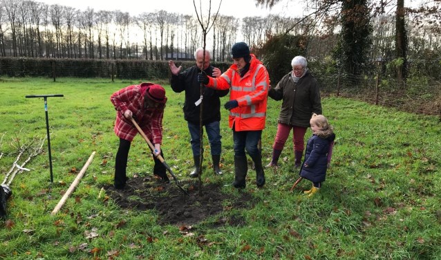 Wethouder Willemien Vreugdenhil plant de eerste boom, samen met Eric en Geertje Mackay en kleinkind Fiene.