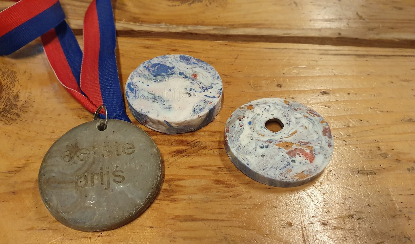 Drie medailles van gerecycled plastic gemaakt door de Recycle Fabriek.