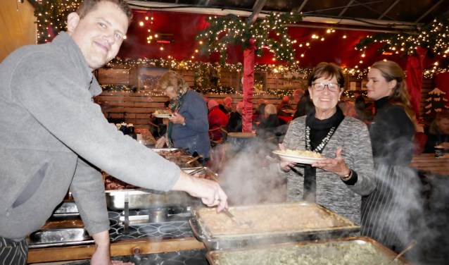 Poffertjes, oliebollen, warme chocola, aan alles is gedacht op de Warme Witte Winterweken. Alie van Nieburg (midden) doet al dertig jaar mee.