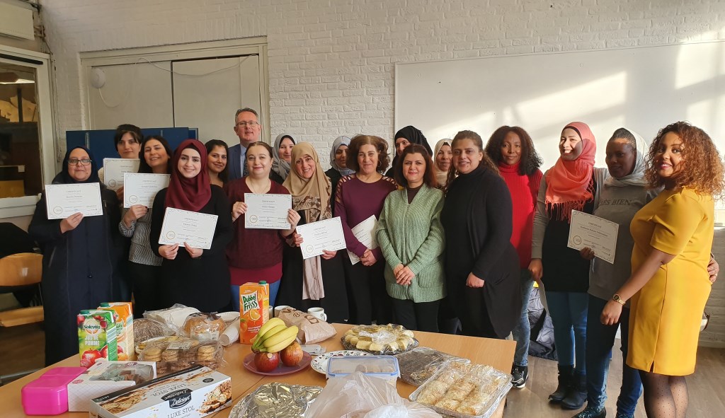 De vrouwen met hun certificaat, de trainers en de wethouder. Iedereen is trots op de inzet van deze dames.