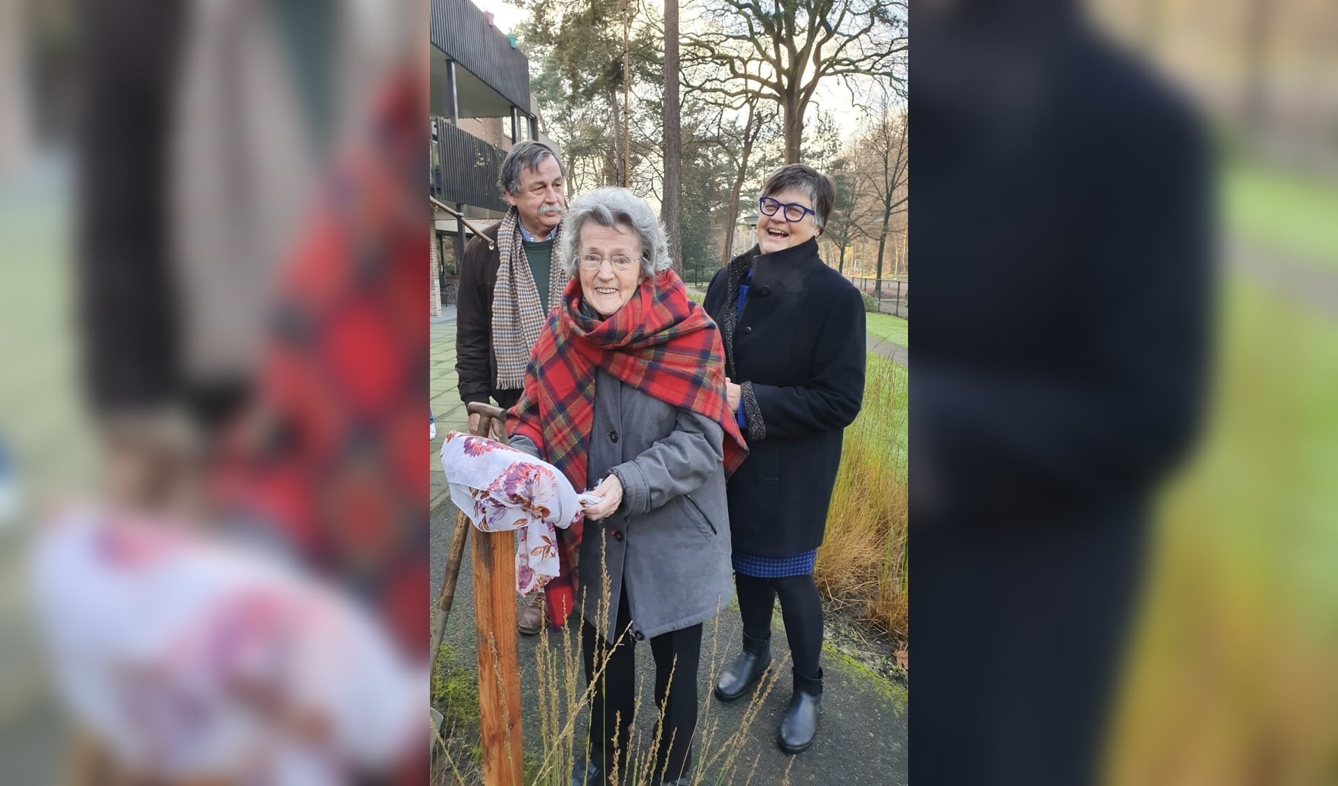 Mw. Zonneveld onthult haar naamplaatje bij de geplante boom. 