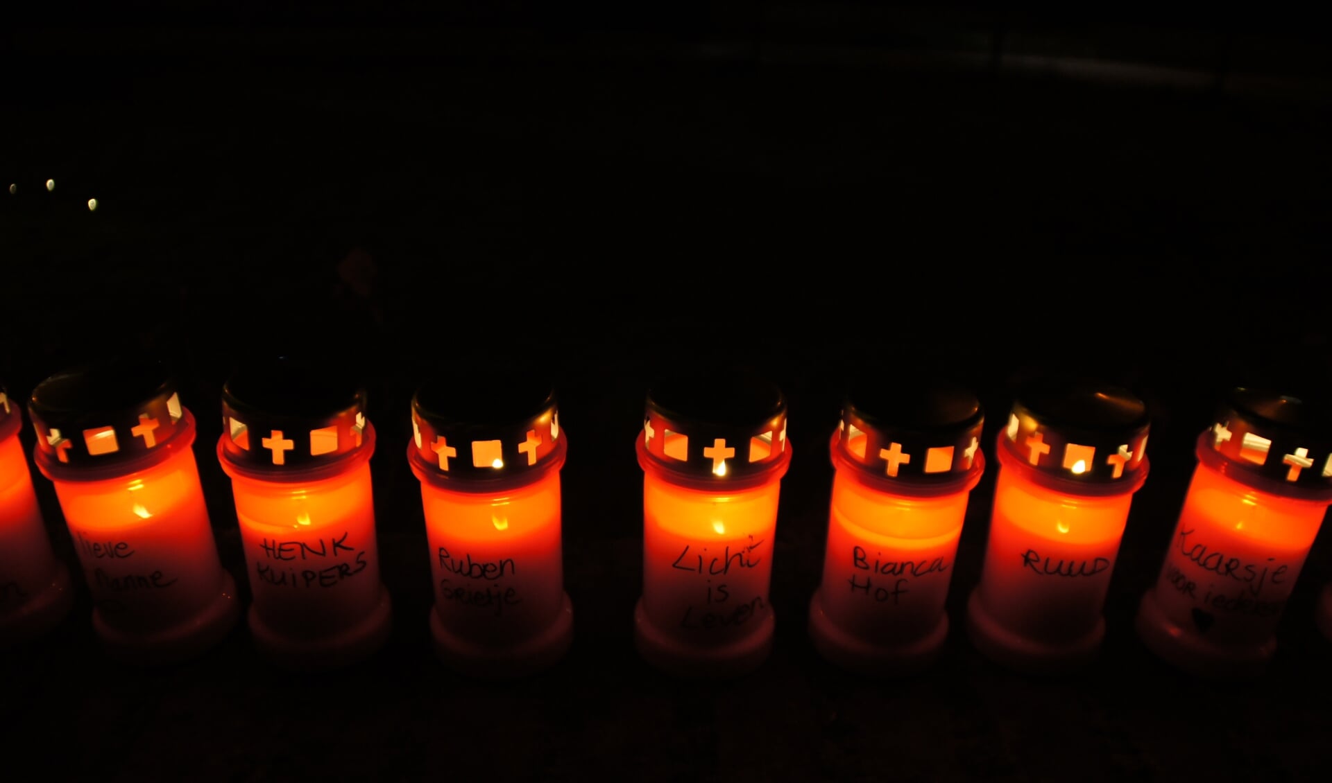 Op de kaarsen staan verschillende teksten, waaronder één met 'Licht is leven'.