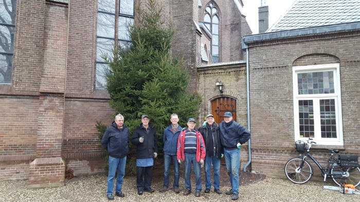 vrijwilligers zetten de kerstboom op zijn plek