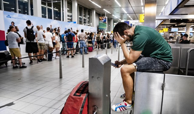 Een van de vele wachtende passagiers tijdens de storing op Schiphol.