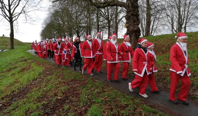 In grote getale lopen of rennen de kerstmannen over de stadswallen.