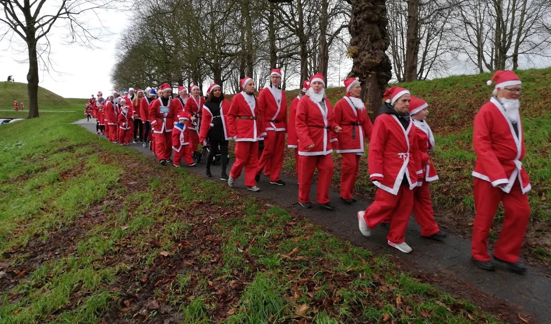In grote getale lopen of rennen de kerstmannen over de stadswallen. 