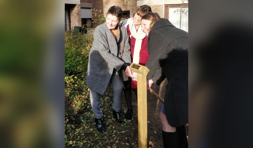 Dochters en kleindochter bij de boom voor de 100 jarige in de tuin van Zorglocatie Oranjestein