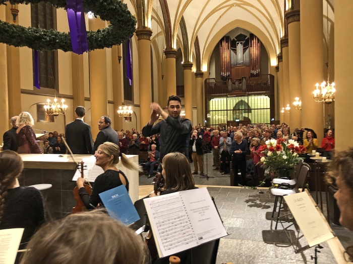 Dirigent Anthony Scheffer applaudisseert het orkest en het koor na afloop van het concert.