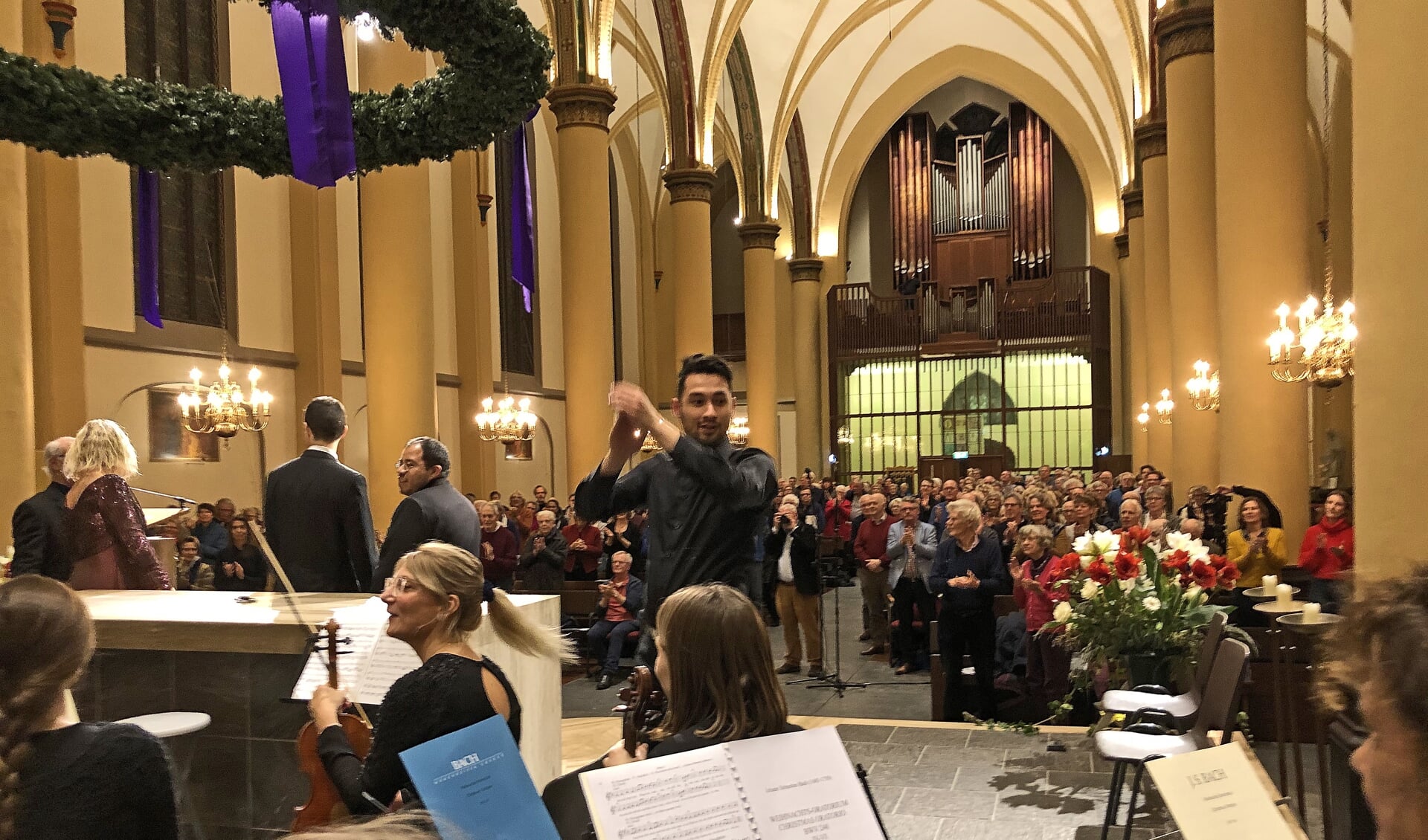 Dirigent Anthony Scheffer applaudisseert het orkest en het koor na afloop van het concert.