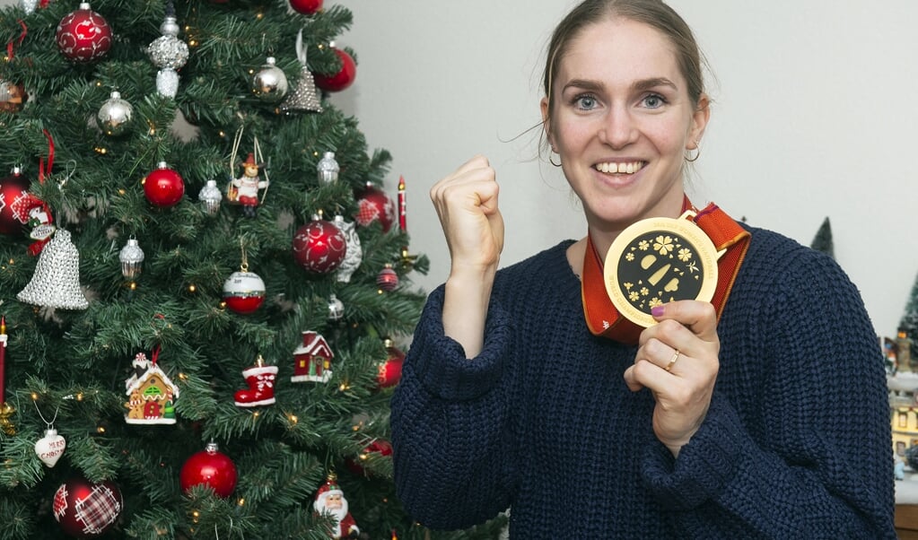 Vol trots toont Laura van der Heijden haar gouden medaille, in het ouderlijk huis in Leusden.