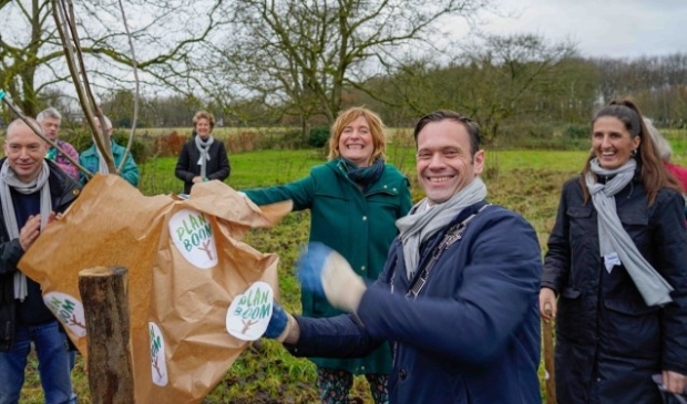 De allereerste boom wordt geplant door burgemeester Potters van de Bilt. Ruim vijftig vrijwilligers, van jong tot oud, hielpen mee de bomen in de grond te zetten. Foto: Jack Tillmanns