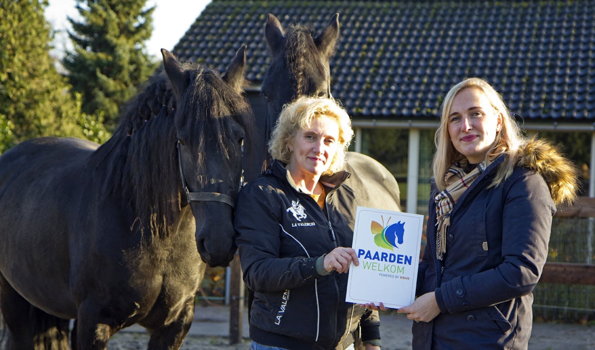 Wil van Wagensveld van De Oscarhoeve (links) ontvangt het Paarden Welkom bord van Eileen Bakker van de KNHS