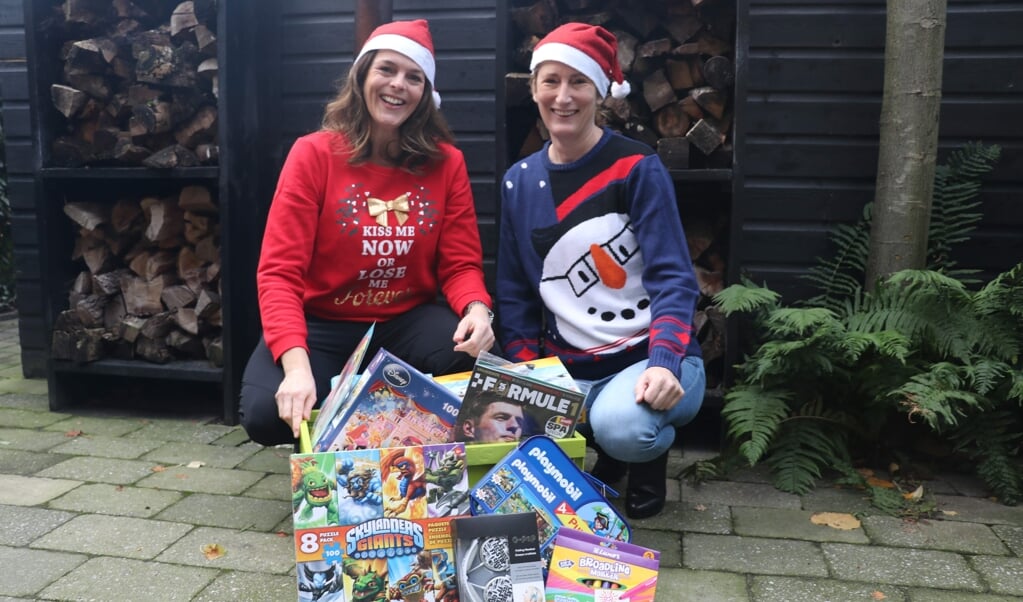 Annemiek Gras en Daphne Hoogma stellen kerstpakketten samen voor gezinnen die een moeilijk jaar achter de rug hebben.