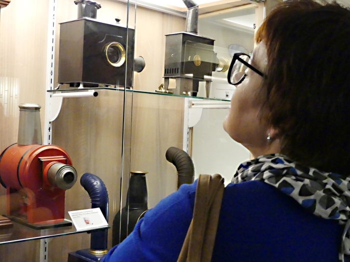 Een bezoeker bewondert een aantal toverlantaarns, die tentoongesteld zijn in het Kijk en Luistermuseum