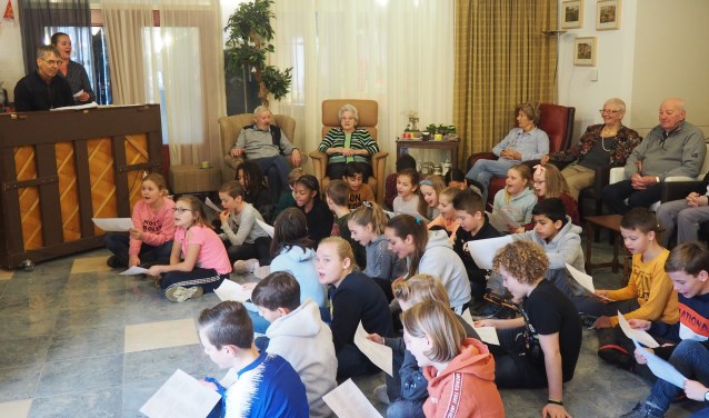 Kinderen van de Uilenburcht zingen, onder pianobegeleiding van Meester Dik, sinterklaasliedjes met de bewoners van Rehoboth.