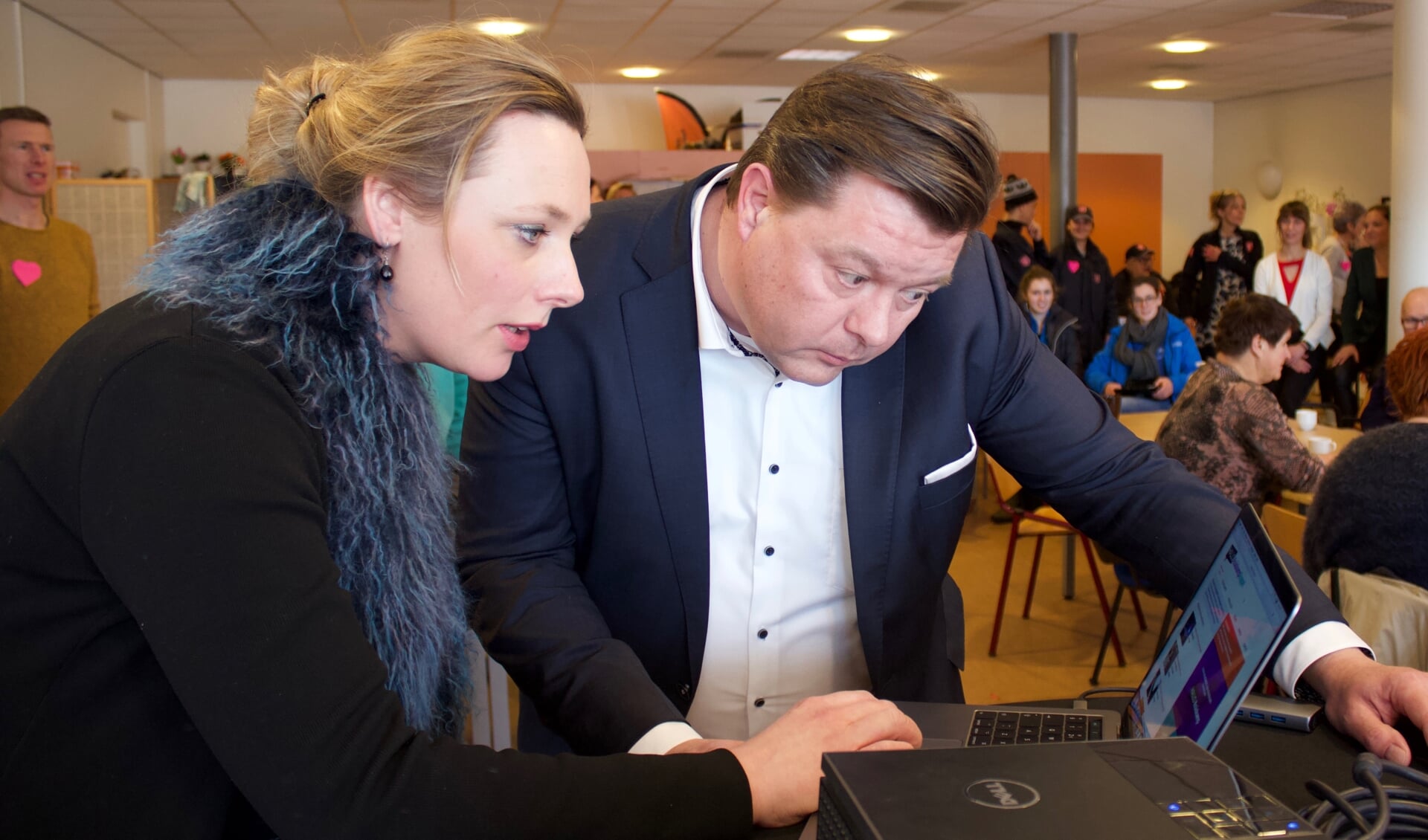 Redactielid Eline de Boer laat aan wethouder Kees Kraanen de website zien. 