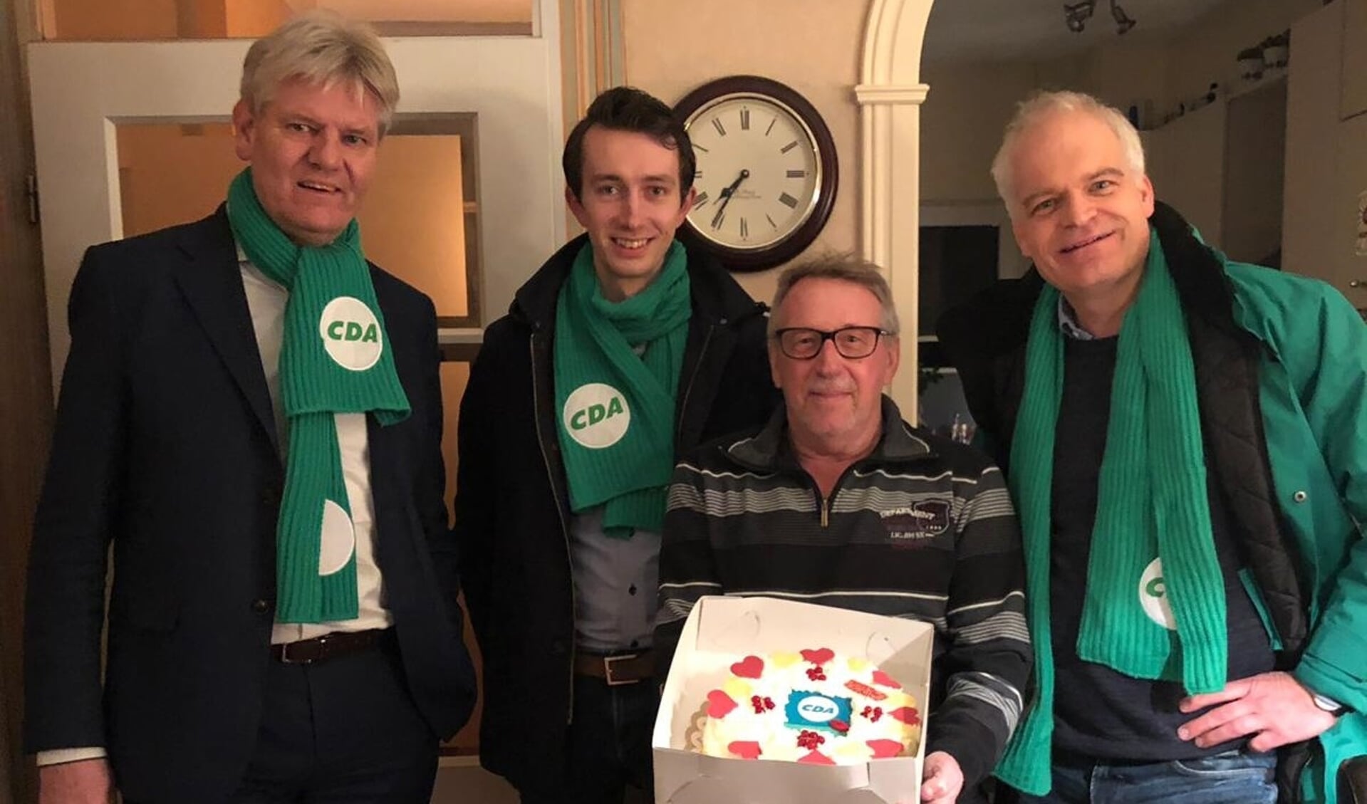 Jan Wagenaar neemt een taart in ontvangst van Bert Komdeur