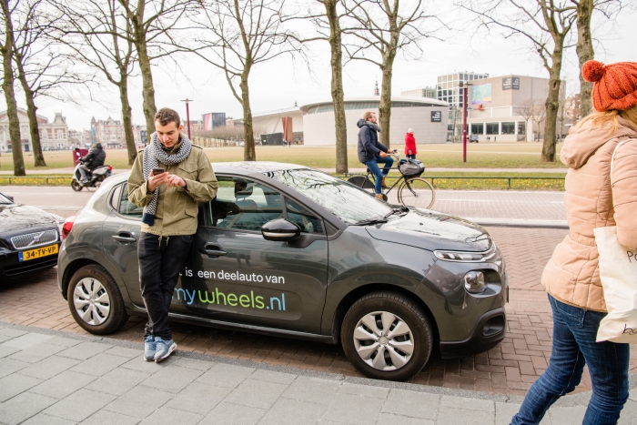 Een autodeler opent de MyWheels auto met zijn smartphone