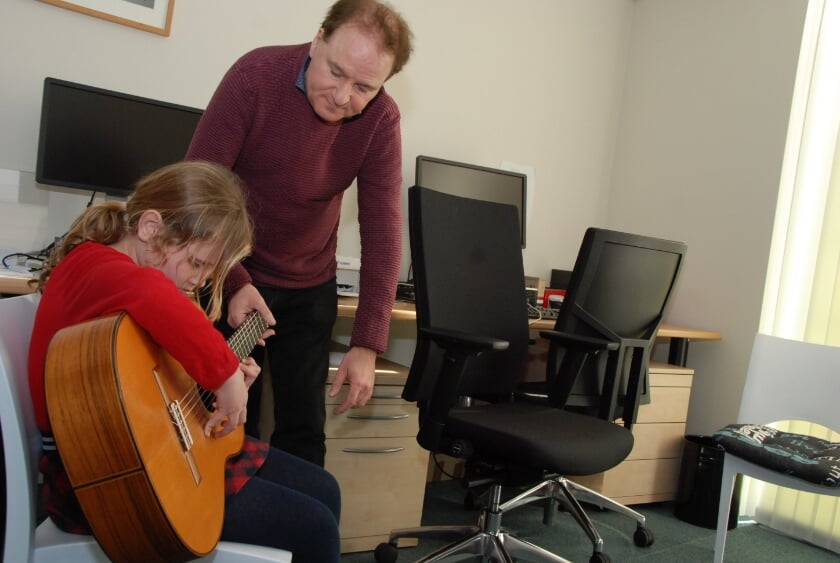 Marno Wieken geeft aanwijzingen aan een leerling die gitaar wil leren spelen.