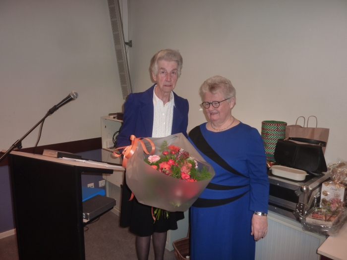 Mw. H. de Kruif- Versteeg (links) 60-jaar lid Samen Verder krijgt bloemen aangeboden door Mw. H. Mons (rechts).