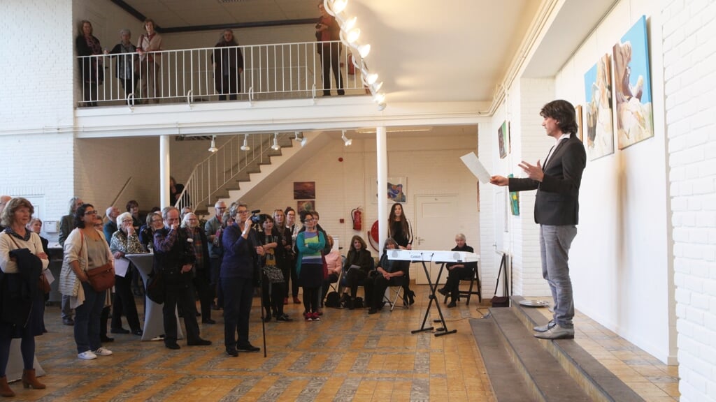 De vorige stadsdichter Matthijs den Hollander in actie tijdens de opening van een expositie.