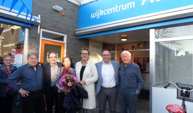 Wethouder Meijs, met de witte jas, bij de onthulling van de nieuwe naam van Wijkcentrum Alleman in de Jan Sluyterslaan.