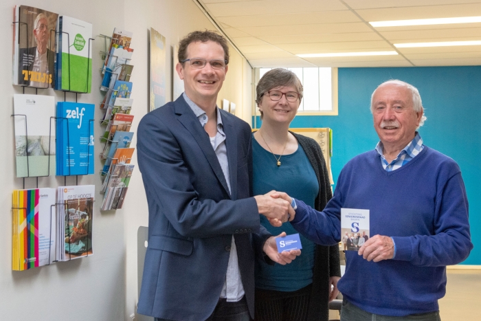 Overhandiging van het logo en de folder aan Louk Kerkhoffs