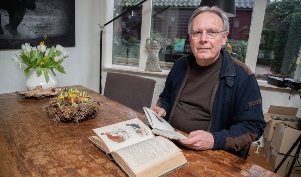 Natuurotograaf Jan van der Greef met op tafel het boek waar het allemaal mee begon en in zijn hand de nieuwe reisverhalenbundel.
