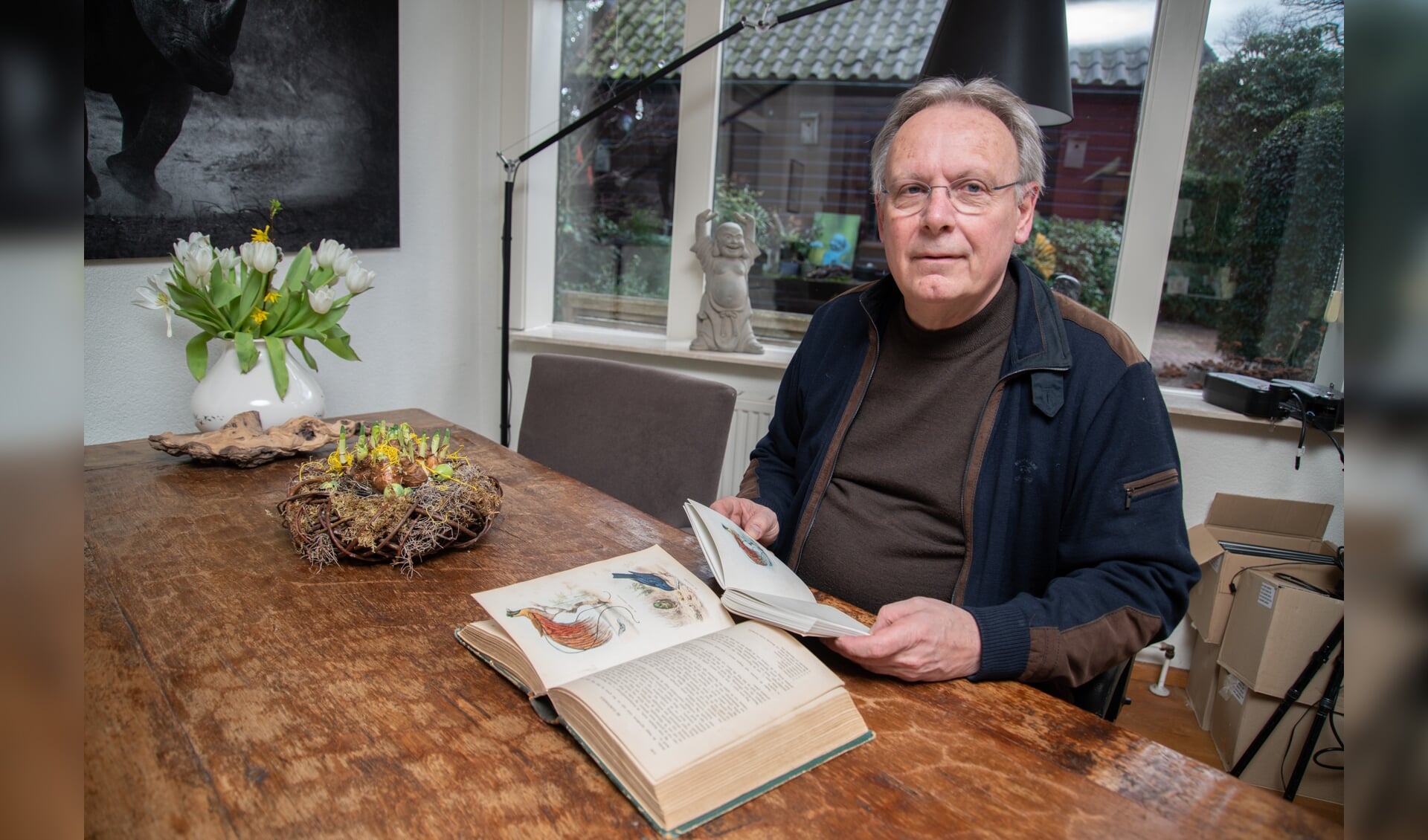 Natuurotograaf Jan van der Greef met op tafel het boek waar het allemaal mee begon en in zijn hand de nieuwe reisverhalenbundel.
