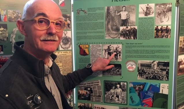 Chris Bor wijst op een foto waar hij zelf op staat bij de expositie over sport in Driebergen.