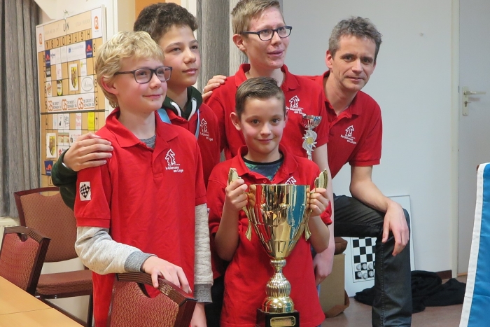 Het winnende team met een trotse coach