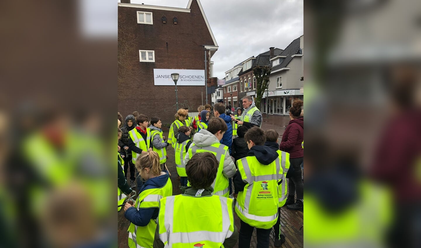 Burgemeester Naafs deelt prikstokken uit aan de leerlingen.