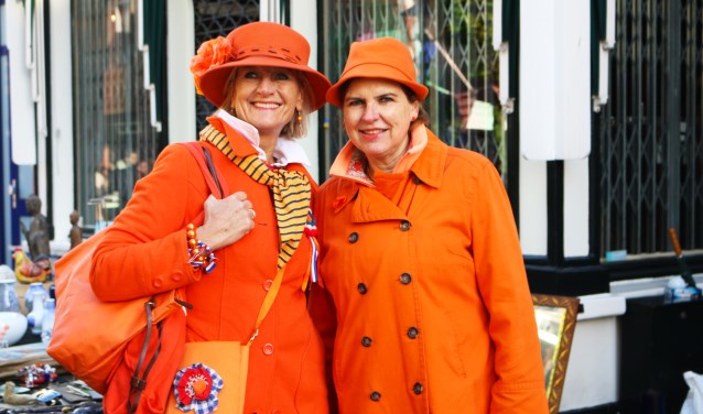 Twee in oranje geklede dames vieren Koningsdag in Baarn