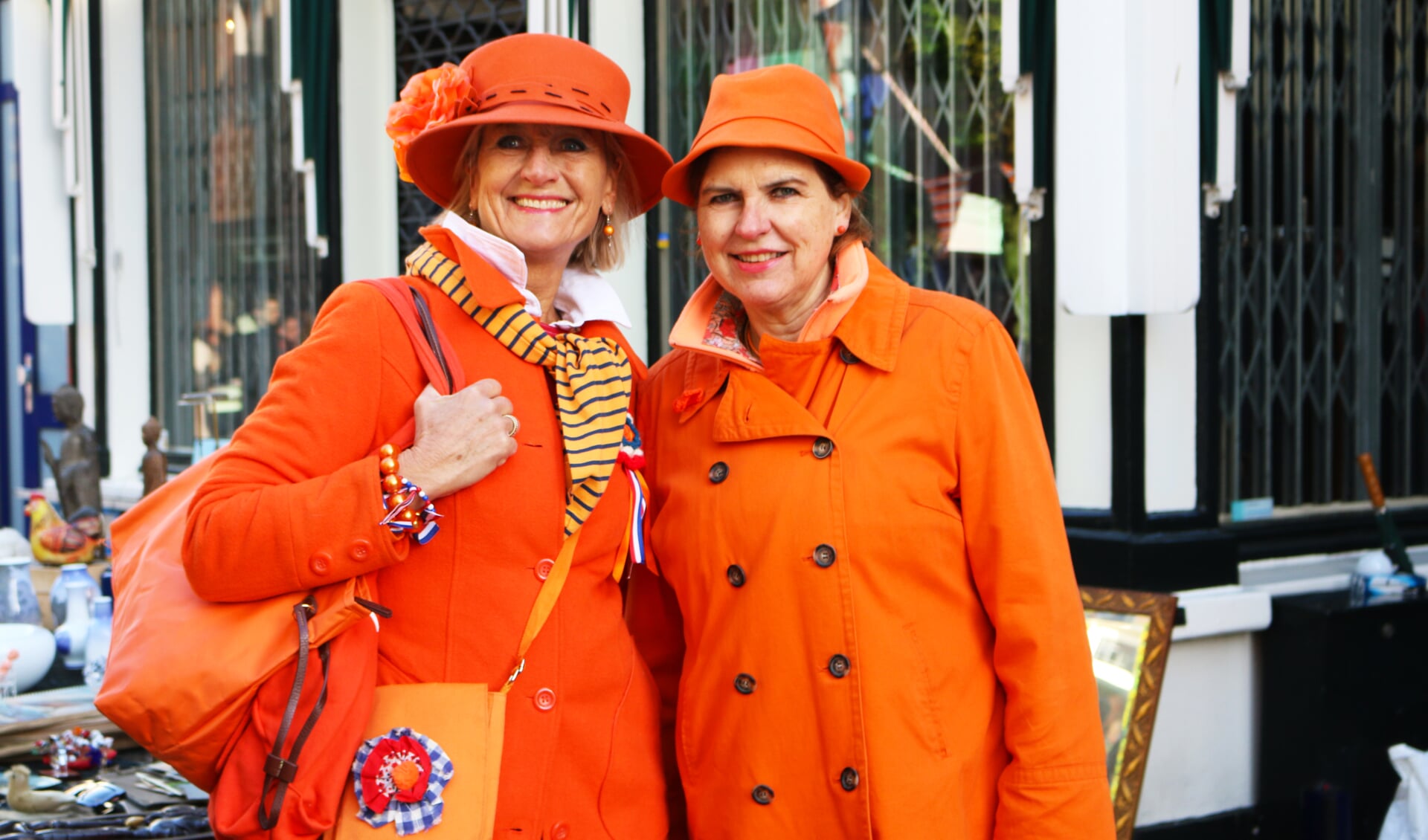 Twee in oranje geklede dames vieren Koningsdag in Baarn