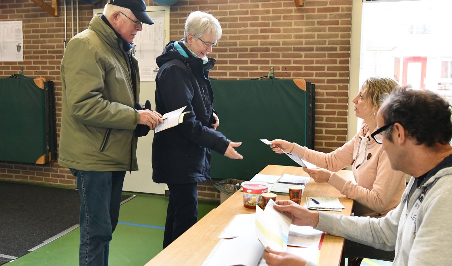 Het echtpaar Overeem krijgt de stembiljetten overhandigd in een stemlokaal in Overhees. De opkomst in Soest lag met 62,7 procent ruim twee procent boven die van de provincie.