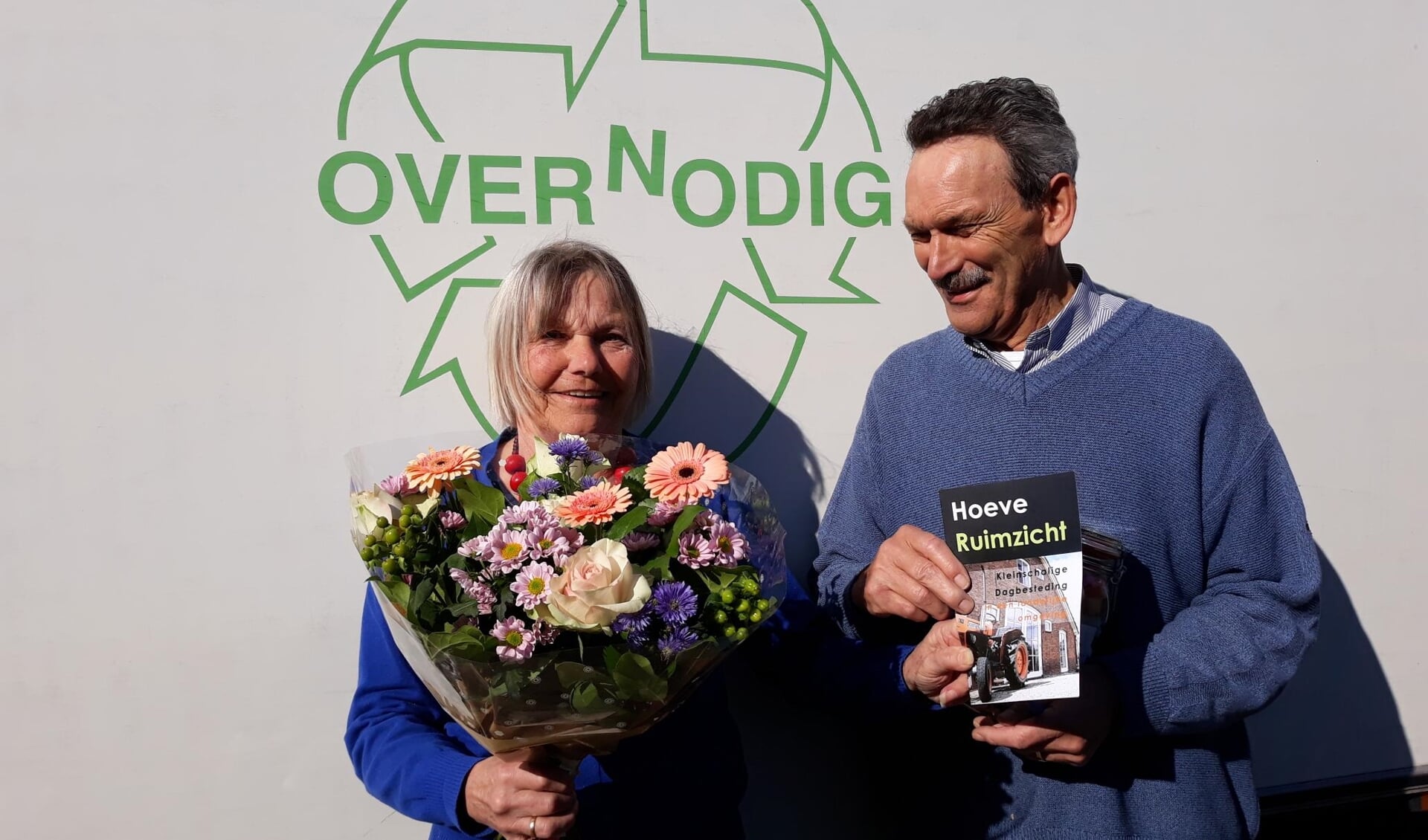 Foto van overhandiging bos bloemen door gast Hoeve Ruimzicht aan medewerker van Overnodig.