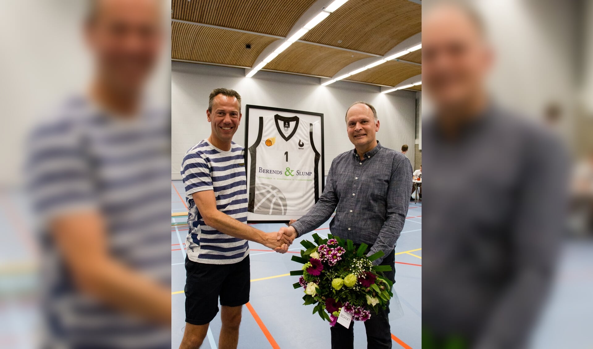 Voorzitter Alex Bos (r) overhandigt Krispijn Langereis (l) bloemen en een ingelijst shirt aan als dank voor de sponsoring van de U12