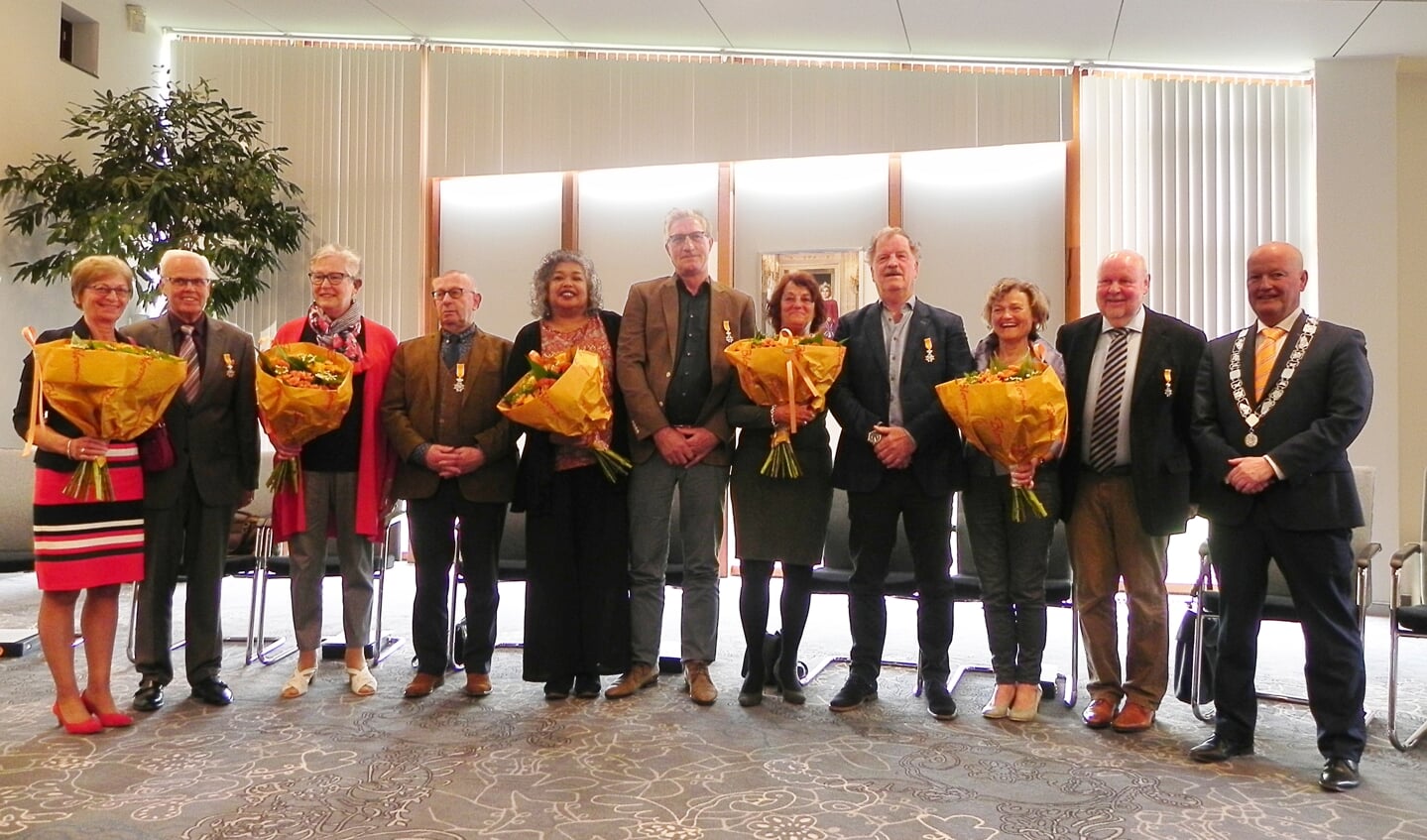 De 5 gedecoreerde mannen poseren met hun net verkregen lintje,  hun partners en burgemeester Ruud van Bennekom.