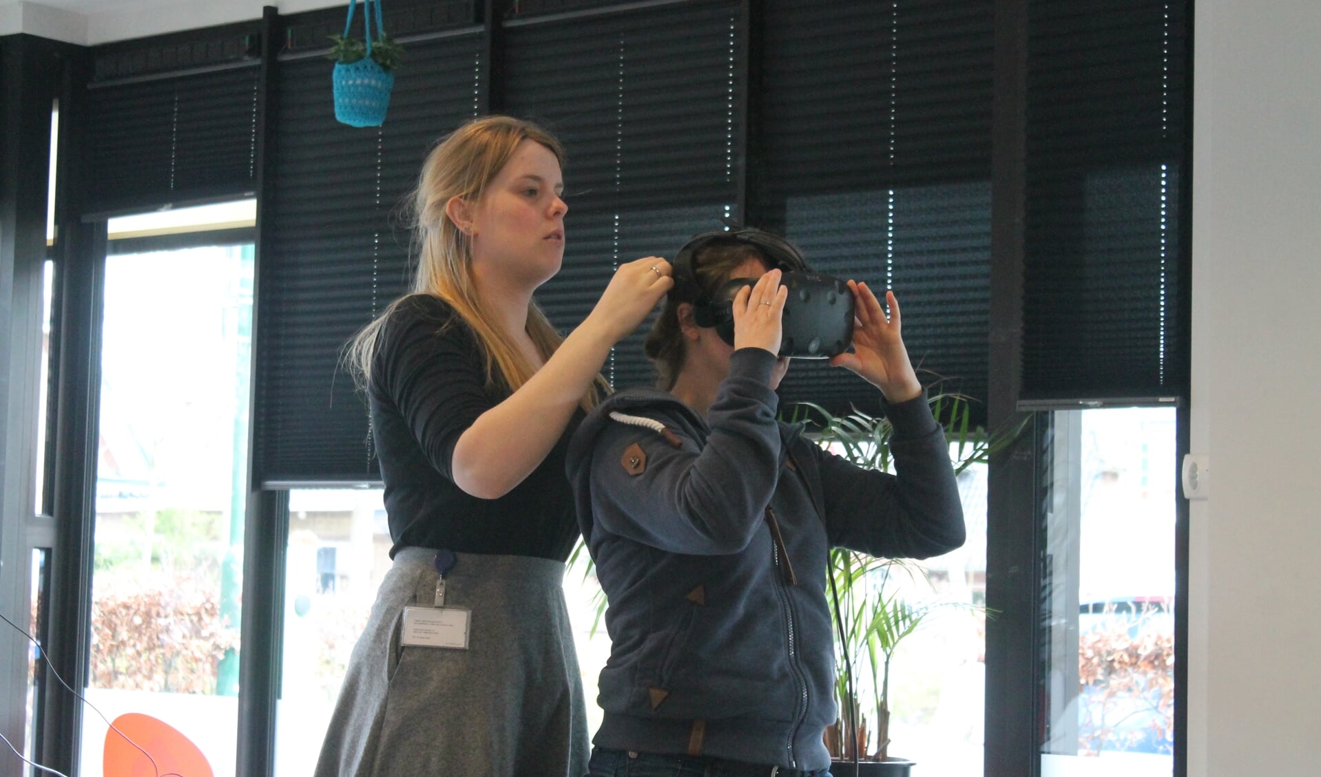 Marleen helpt Indra om de VR bril op te zetten