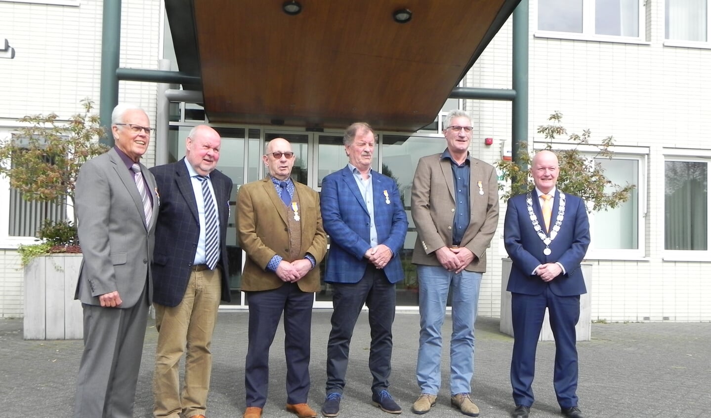 De 5 gedecoreerde mannen poseren buiten voor het stadhuis met hun net verkregen lintje en burgemeester Ruud van Bennekom.